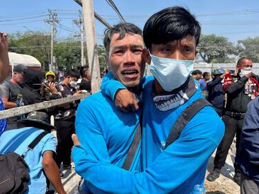 Los trabajadores reaccionan cerca del lugar donde se derrumbó un edificio después de que los temblores de un fuerte terremoto.