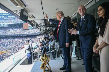 Donald Trump saluda a los aficionados, mientras Gianni Infantino aplaude y su esposa, Leena Al Ashqar, voltea a la grada. (Photo by Brendan SMIALOWSKI / AFP)