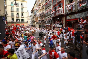 Participantes corren delante de los toros durante el primer encierro de los Sanfermines en Pamplona.