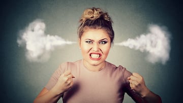 Closeup portrait angry young woman blowing steam coming out of ears, about to have nervous atomic breakdown screaming isolated black background. Negative human emotion face expression feeling attitude