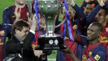 Tito Vilanova levanta el trofeo liguero junto a Abidal.