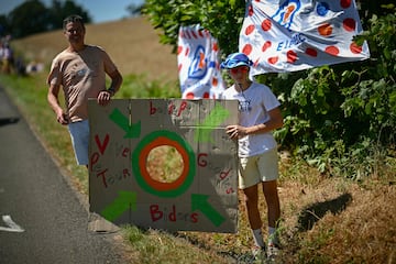 Un espectador se alinea a lo largo de la ruta de la carrera con un objetivo de cartón improvisado para atrapar artículos promocionales ("goodies") distribuidos por la caravana publicitaria del Tour de Francia, así como botellas de hidratación para ciclistas (llamadas "bidones") durante la sexta etapa de la 112.ª edición del Tour de Francia, entre Bayeux y Vire Normandie.