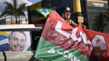 BRASILIA, BRAZIL - OCTOBER 1 : A supporter of Brazil's former President and presidential candidate Luiz Inacio Lula da Silva holds a flag during a motorcade to support local candidate in Brasilia, Brazil October 1, 2022. Around 156 million Brazilians will head to the polls Sunday to cast their ballots for the next president in a country where voting is compulsory. A number of key positions are in contention as 11 candidates vie to become Brazil's next leader. (Photo by Mateus Bonomi/Anadolu Agency via Getty Images)