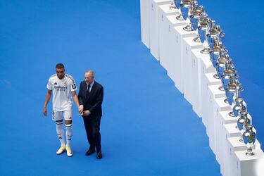 Florentino Pérez coge de la mano a Kylian Mbappé durante la presentación.