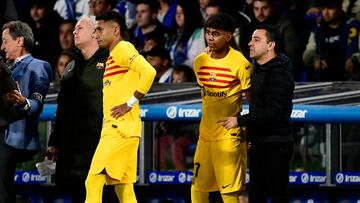 Barcelona's Spanish coach Xavi stands next to Barcelona's Spanish forward #27 Lamine Yamal and Barcelona's Brazilian forward #11 Raphinha on the sidelines during the Spanish league football match between Real Sociedad and FC Barcelona at the Anoeta stadium in San Sebastian on November 4, 2023. (Photo by ANDER GILLENEA / AFP)