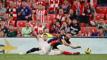 BILBAO, 27/04/2023.- El centrocampista del Sevilla Lucas Ocampos (i) cae ante el portero Unai Simón, del Athletic, durante el partido de LaLiga Santander entre el Athletic de Bilbao y el Sevilla que disputan este jueves en el estadio de San Mamés, en Bilbao. EFE/Luis Tejido