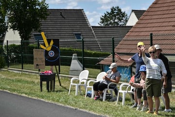 Espectadores con una red improvisada para atrapar los artículos promocionales ("goodies") distribuidos por la caravana publicitaria del Tour de Francia, así como las bidones de los ciclistas.