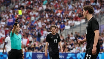 New Zealand's defender #13 Lukas Kelly-Heald (R) reacts as Mexican referee Katia Garcia (L) shows him a yellow card during the Paris 2024 Olympic Games men's group A football match between New Zealand and France, at the Marseille Stadium, in Marseille, southern France, on July 30, 2024. (Photo by Pascal GUYOT / AFP)
