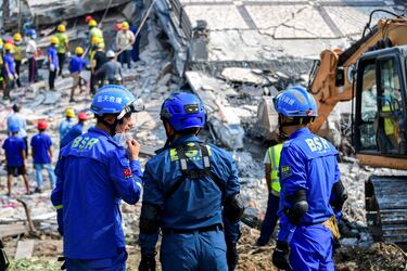 Rescatistas chinos se encuentran en el lugar del derrumbe de un edificio tras un fuerte terremoto en Mandalay, Myanmar.