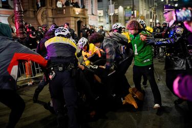 Oficiales de policía se enfrentan con fanáticos mientras se reúnen para celebrar el triunfo de los Philadelphia Eagles.