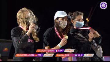 De izquierda a derecha, las skaters Daniela Terol (2ª), Charlotte Hym (1ª) y Camila Ruiz (3ª) en el podio del ImaginExtreme Barcelona 2020, mostrando sus medallas de plata, oro y bronce, con la mascarilla puesta y con viento soplando.