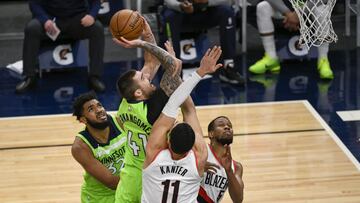Minnesota Timberwolves forward Juancho Hernangomez (41) shoots over Portland Trail Blazers center Enes Kanter (11) and guard Rodney Hood, right, as Timberwolves center Karl-Anthony Towns (32) watches during the first half of an NBA basketball game Saturday, March 13, 2021, in Minneapolis. (AP Photo/Craig Lassig)