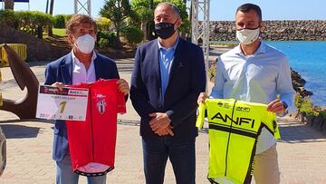 Pedro Delgado posa con el maillot el dorsal número 1 de la edición de 2021 de la Free Motion Desafío La Titánica en Gran Canaria junto al Consejero de Deportes del Cabildo de Gran Canaria Francisco Castellanos y el concejal de Deportes del Ayuntamiento de Mogán Luis Becerra.