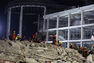 El personal de rescate permanece de pie y sentado en el lugar de un edificio que se derrumbó después de que un fuerte terremoto sacudiera el centro de Myanmar