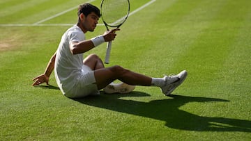 Carlos Alcaraz cae durante su partido contra Jannik Sinner en Wimbledon.