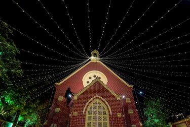 Un hombre instala luces decorativas en una iglesia antes de las celebraciones navideñas en Ahmedabad, India.