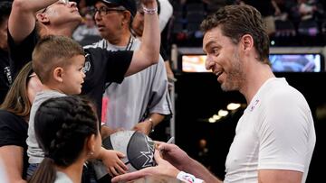 Pau Gasol firma un balón a un niño.