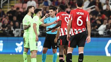 Spanish referee Miguel Ortiz listens to his headset during the Spanish Super Cup semi-final football match between Athletic Bilbao and Barcelona at the King Abdullah Sport City in Jeddah on January 8, 2025. (Photo by FADEL SENNA / AFP)