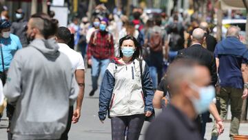 Varias personas caminan en Gran Vía con mascarilla.