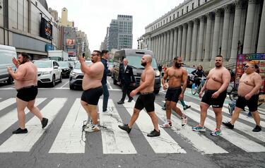 Varios luchadores del Campeonato Mundial de sumo (WCS) posan para unas fotografías mientras cruzan la Octava Avenida, a las afueras del Madison Square Garden. La imagen forma parte de un acto promocional de 'El espectáculo más grande del mundo', un evento que cuenta con Rikishi (luchadores) enfrentándose en emocionantes combates.