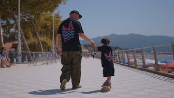 Pity y su hijo andando con una camiseta de Marisquiño por la playa de Samil, Vigo, en agosto del 2025.