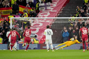 El delantero francés del Real Madrid lanza con pierna derecha desde los once metros a la izquierda de Caoimhín Kelleher y adivina el disparo.Gran parada del portero del Liverpool.