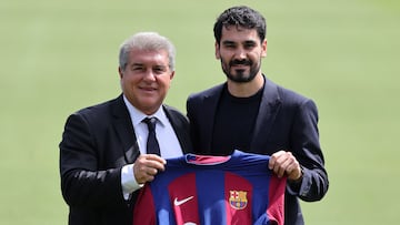 FC Barcelona's newly-signed German midfielder Ilkay Gundogan (R) poses for pictures holding his jersey with FC Barcelona's President Joan Laporta during his official presentation at the Joan Gamper training ground in Sant Joan Despi on July 17, 2023. (Photo by LLUIS GENE / AFP)