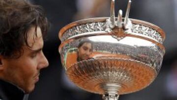 Rafa Nadal observa la Copa de los Mosqueteros conseguida en Roland Garros.