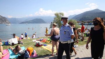 Imagen de un policía observando que se cumplen las medidas de seguridad en la orilla del lago Iseo.