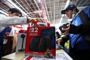 A man buys a Nintendo Switch 2 gaming device as Nintendo starts selling the new consoles globally, at an electronics store in Tokyo, Japan June 5, 2025.  REUTERS/Issei Kato