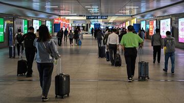 Passengers wearing face masks arrive at Hankou railway station in Wuhan, Hubei Province on May 12, 2020. - China reported no new domestic coronavirus infections on May 12, after two consecutive days of double-digit increases, including a new cluster over the weekend in Wuhan, which fuelled fears of a second wave of infections. (Photo by Hector RETAMAL / AFP)