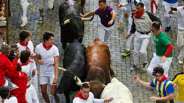 Participants run ahead of Victoriano del Rio bulls during the fourth running of the bulls of the San Fermin festival in Pamplona, northern Spain, on July 10, 2025. Thousands of people every year attend the week-long festival and its famous "encierros" or bull runs, every day at 8:00 a.m. through the narrow streets of the old town over an 850 meters (yard) course while runners ahead of them try to stay close to the bulls without falling over or being gored. (Photo by ANDER GILLENEA / AFP)