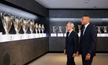 Kylian Mbappé y Florentino Pérez viendo la sala de trofeos del Real Madrid.