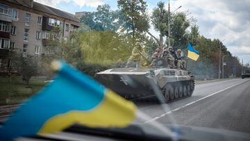 Ukrainian service members ride on an armoured fighting vehicle in the town of Kupiansk, recently liberated by the Armed Forces, amid Russia's attack on Ukraine, in Kharkiv region.