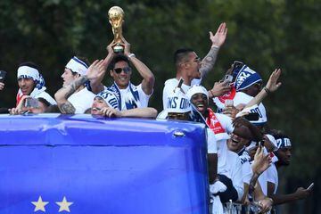 France's defender Raphael Varane holds the trophy as he celebrates with teammates on the roof of a bus while parading down the Champs-Elysee avenue after winning the Russia 2018 World Cup final football match, in Paris, France July 16, 2018. Eric Feferber