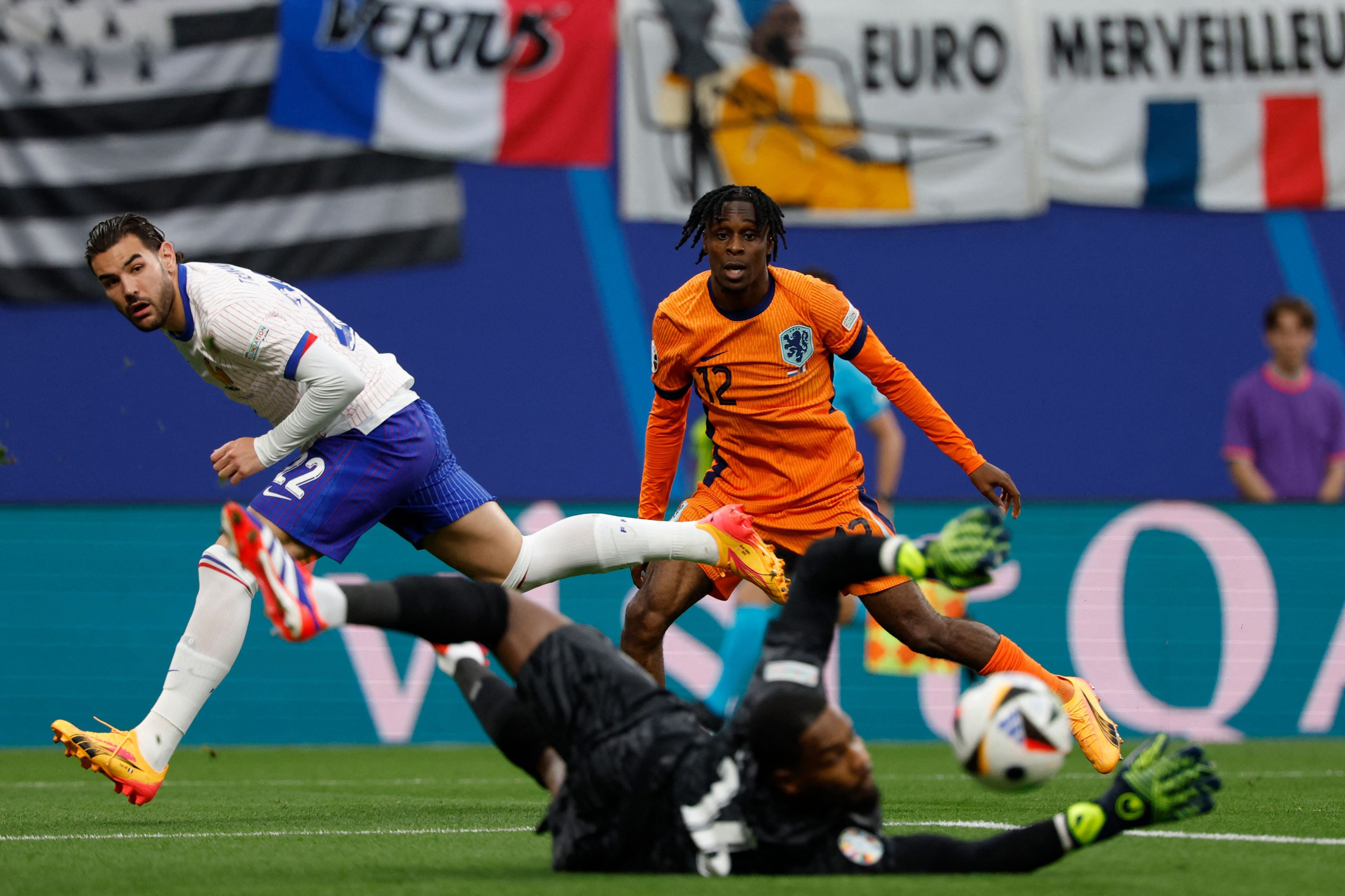 (From L) France's goalkeeper #16 Mike Maignan (Front) deflects a shot by Netherlands' forward #12 Jeremie Frimpong (R) as France's defender #22 Theo Hernandez looks on during the UEFA Euro 2024 Group D football match between the Netherlands and France at the Leipzig Stadium in Leipzig on June 21, 2024. (Photo by Odd ANDERSEN / AFP)