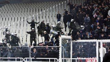 Polic&iacute;as griegos tratan de controlar a aficionados de Ajax hoy, en un partido de la Liga de Campeones entre AEK y Ajax en el estadio OAKA en Atenas (Grecia).