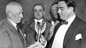 Jules Rimet (izquierda), presidente de la FIFA, entrega el trofeo de la Copa del Mundo a Raúl Jude, presidente de la Federación Uruguaya, antes de la celebración de la primera edición del torneo en 1930.