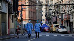 FILE PHOTO: Workers in protective suits walk with a cart along a street during lockdown, amid the coronavirus disease (COVID-19) pandemic, in Shanghai, China, May 25, 2022. REUTERS/Aly Song/File Photo