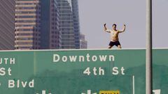 Hombre sobre cartel de autopista, en calzoncillos, en Los Angeles.