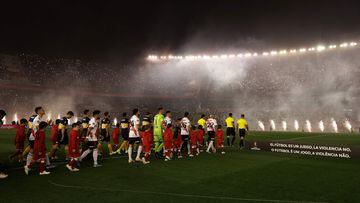 Players of Boca Juniors (blue and yellow) and River Plate (red stripe) step onto the field before the start of their all-Argentine Copa Libertadores semi-final first leg football match at the Monumental stadium in Buenos Aires, on October 1, 2019. (Photo by Alejandro PAGNI / AFP)