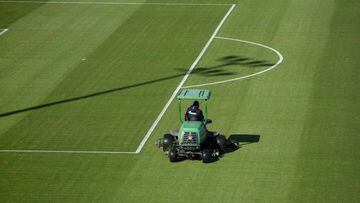 A lawnmower drives on the pitch at the training grounds of German first division Bundesliga football club FC Schalke 04 in Gelsenkirchen, western Germany on May 14, 2020. - Players arriving in several sparsely-populated team buses, substitutes wearing mas