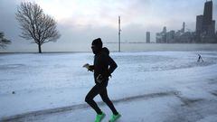 CHICAGO, ILLINOIS - DECEMBER 23: A jogger runs along Lake Michigan at sunrise as temperatures hover about -8 degrees on December 22, 2022 in Chicago, Illinois. Sub-zero temperatures are expected to grip the city for the next couple of days with wind chill temperature dipping as low as -40 degrees.   (Photo by Scott Olson/Getty Images)