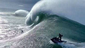  Lucas &#039;Chumbo&#039; Chianca surfeando una ola gigante en Nazar&eacute;, visto desde el lateral, con un jet ski de Red Bull persigui&eacute;ndole para el rescate. 