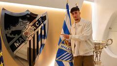 David Larrubia, posando junto a una bandera y escudo del Málaga CF.