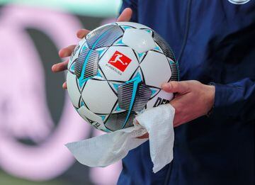 Operario desinfecta el balón en el encuentro entre el RB Leipzig v Sport-Club Friburgo. 