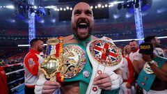 Tyson Fury celebrates with the belts