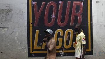 Lagos (Nigeria), 27/05/2020.- Men wearing face masks walk past a wall with an inscription &#039;Our Lagos, Your Lagos&#039;, under a bridge in Lagos, Nigeria, 27 May 2020. The Lagos state government says it is working with the Federal ministry of educatio