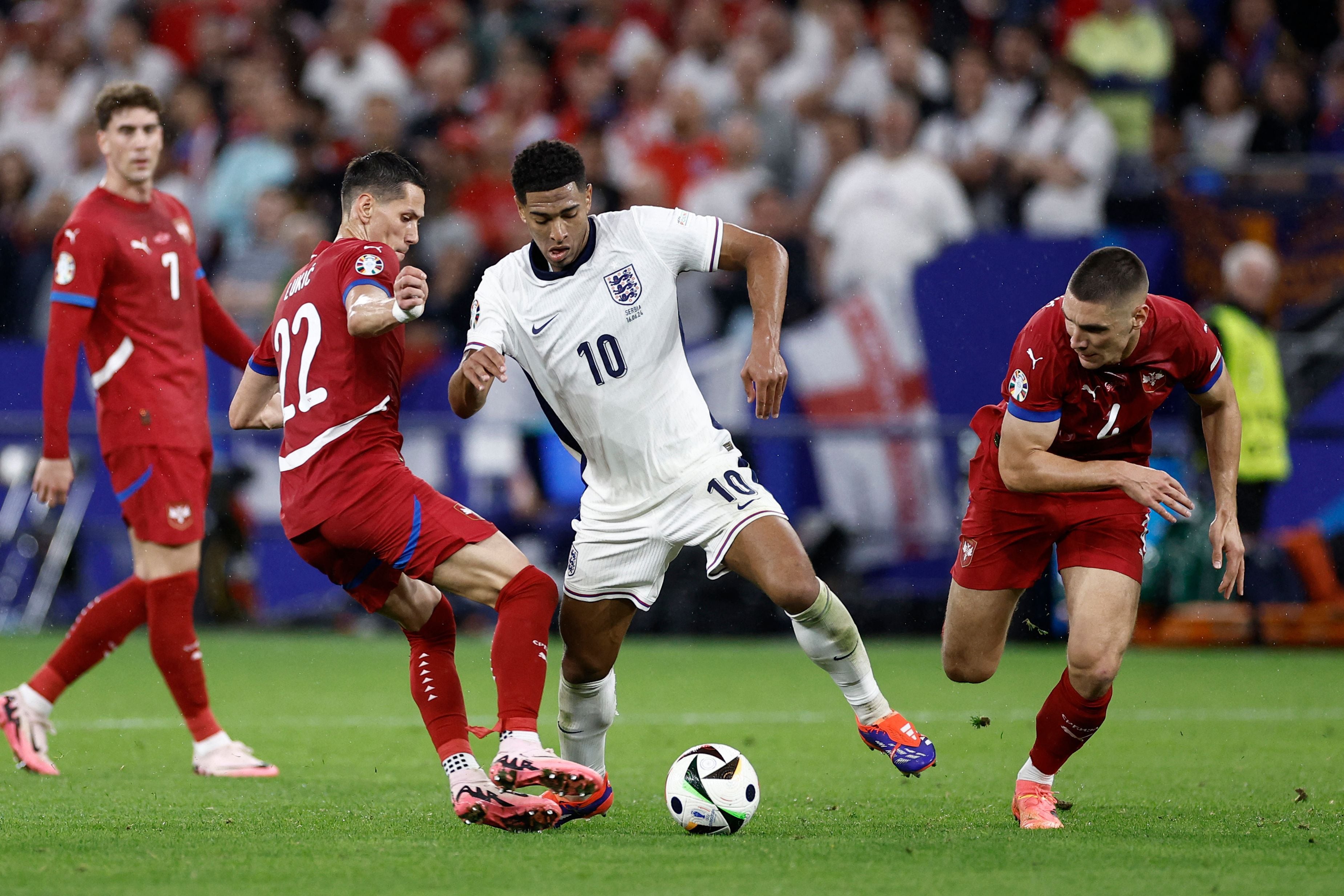 England's midfielder #10 Jude Bellingham (C) and Serbia's midfielder #22 Sasa Lukic (L) vie for the ball during the UEFA Euro 2024 Group C football match between Serbia and England at the Arena AufSchalke in Gelsenkirchen on June 16, 2024. (Photo by KENZO TRIBOUILLARD / AFP)