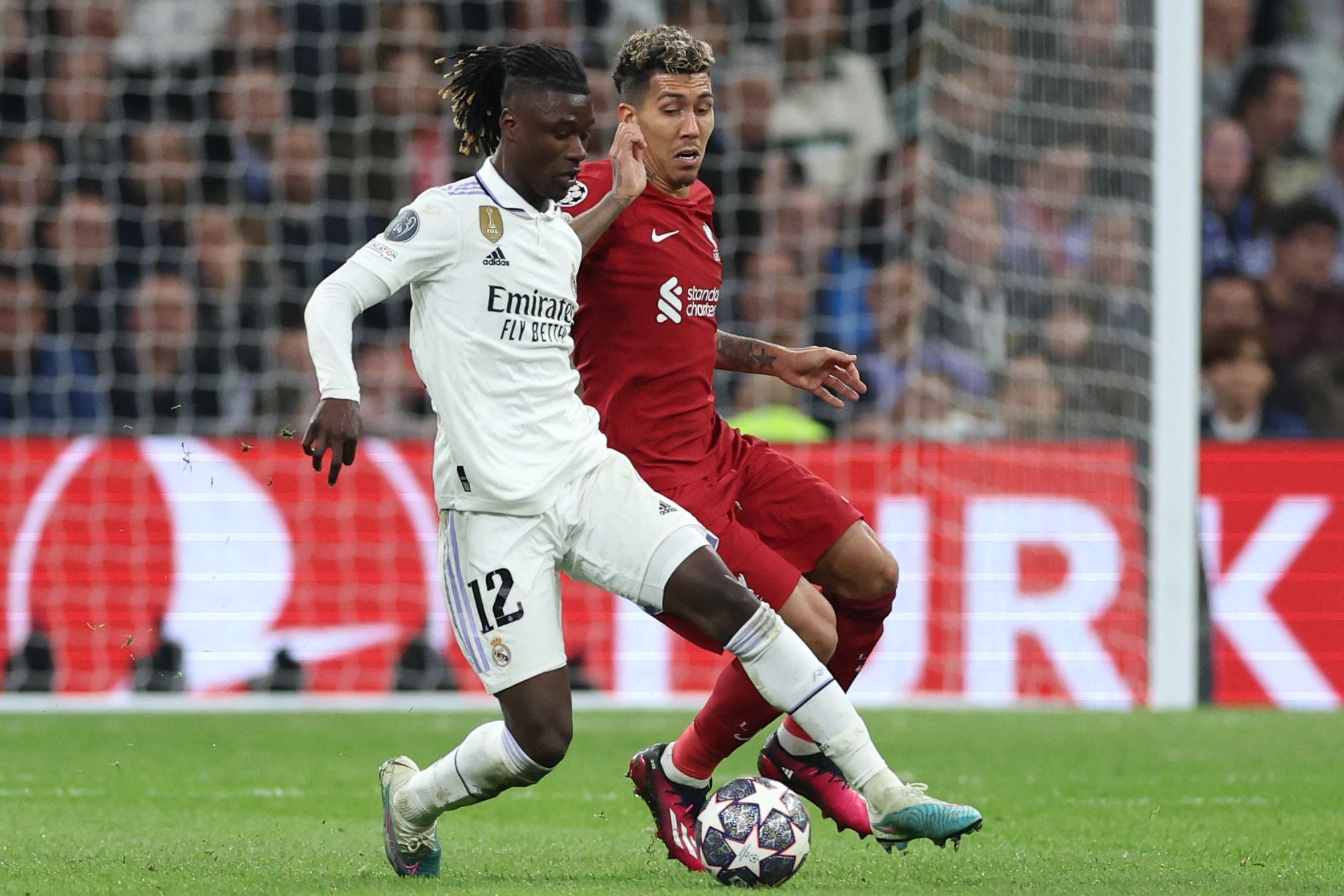 Real Madrid's French midfielder Eduardo Camavinga (L) vies with Liverpool's Brazilian forward Roberto Firmino during the UEFA Champions League last 16 second leg football match between Real Madrid CF and Liverpool FC at the Santiago Bernabeu stadium in Madrid on March 15, 2023. (Photo by Pierre-Philippe Marcou / AFP)